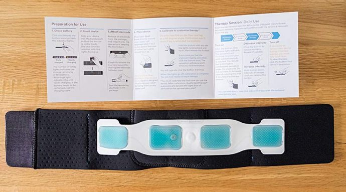 Photo shows the Quell sports band and electrode with the instruction manual. The Quell pain relief device is inserted into a pocket on the band and can't be seen.