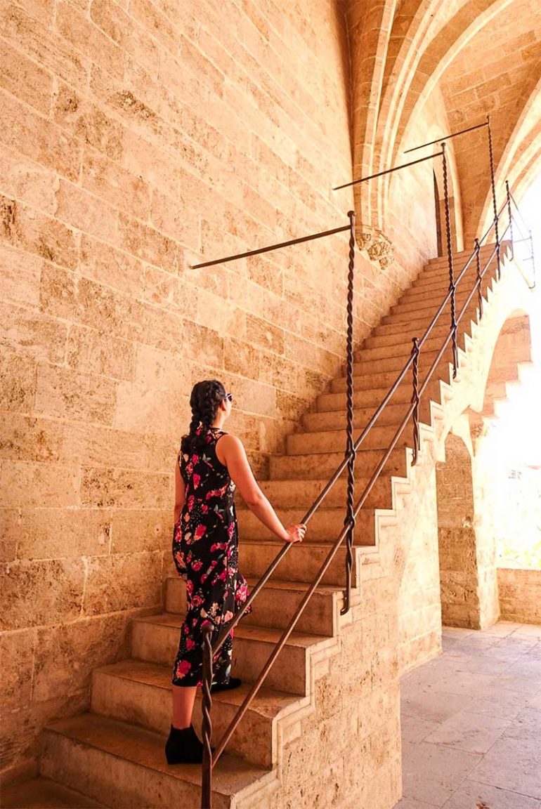 Photo shows Donna walking up concrete steps with the Serrano towers in Valencia.
