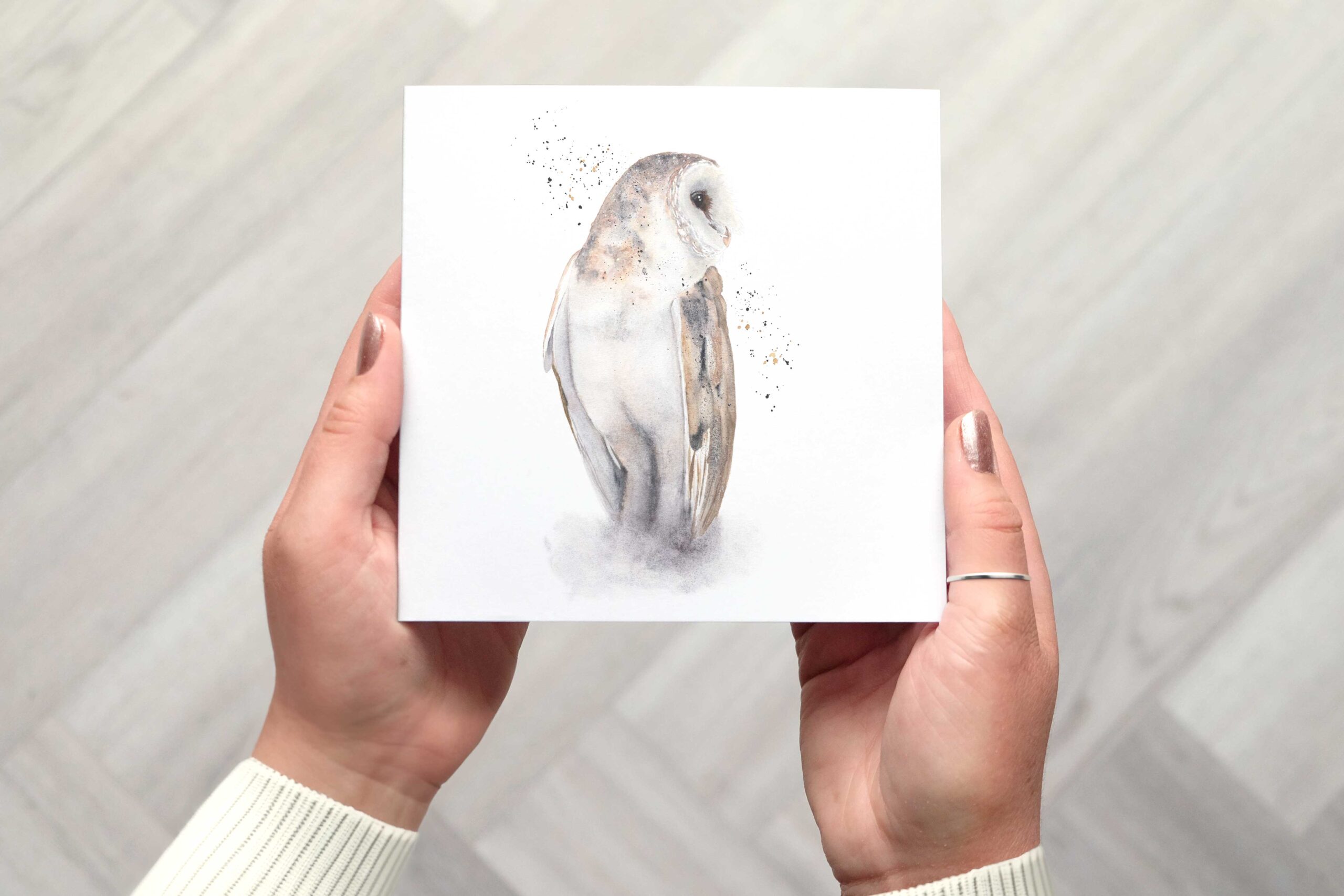 A stunning card featuring a watercolour barn own painting with splatters of paint either side of the bird.