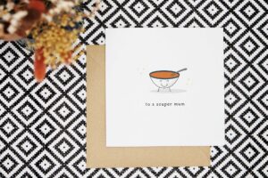 This cute card features an illustrated smiling bowl of soup with two stick legs and a spoon sitting in the bowl. It reads to a souper mum