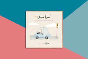 Driving test pass card with a pastel yellow background reads woohoo new driver coming through well done personalised name. It features a cute illustrated goose wearing pink glasses that is driving a blue car along a road through a green traffic light. The goose is leaned back with one wing on the steering wheel and one wing out the window. The card is stylised with yellow stars by the words woo hoo, clouds in the sky and in front of the card reads honk honk in pink text. A little pun reference.