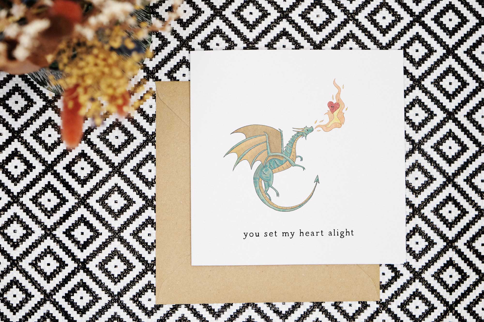 This cute and heartfelt valentines card features a hand drawn dragon breathing fire that engulfs a smiling love heart. The card reads you set my heart alight