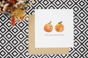 A cute and funny pun card featuring two illustrated peaches and the words love your peachy bum