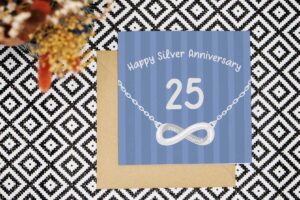 Celebrate 25 years married with this colourful blue striped card that features a silver infinity necklace. The card reads Happy Silver Anniversary. The number 25 is bold in the middle of the card and the words years married look like they have been inscribed into the necklace.